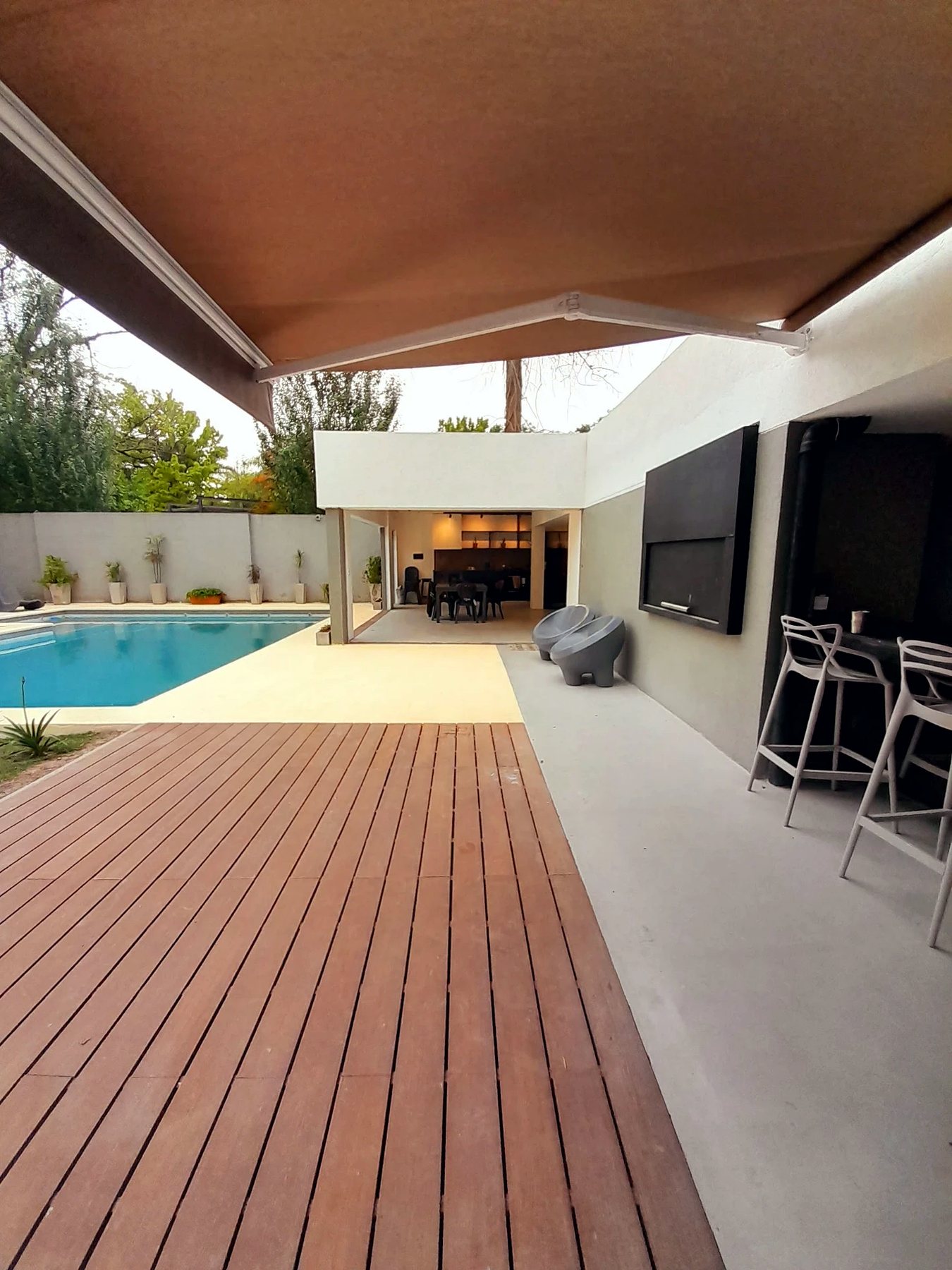 Vivienda de hormigón con piscina y deck de madera